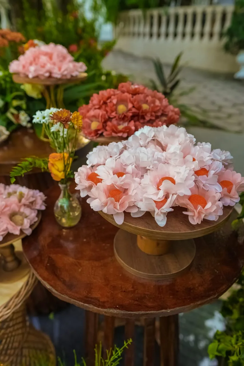 Doces decorados como flores sobre suportes de madeira