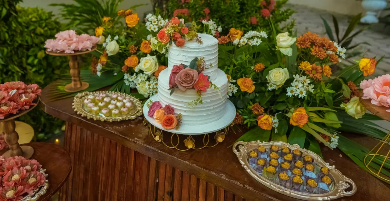 Mesa de bolo e doces com flores coloridas